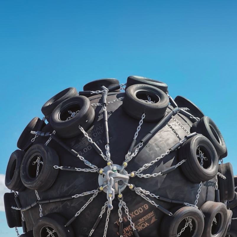 Yokohama pneumatic fenders with tyre net protection against clear blue sky