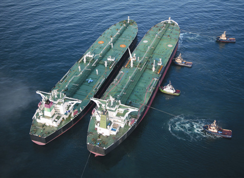 Ship-to-ship transfer at anchor with tugs